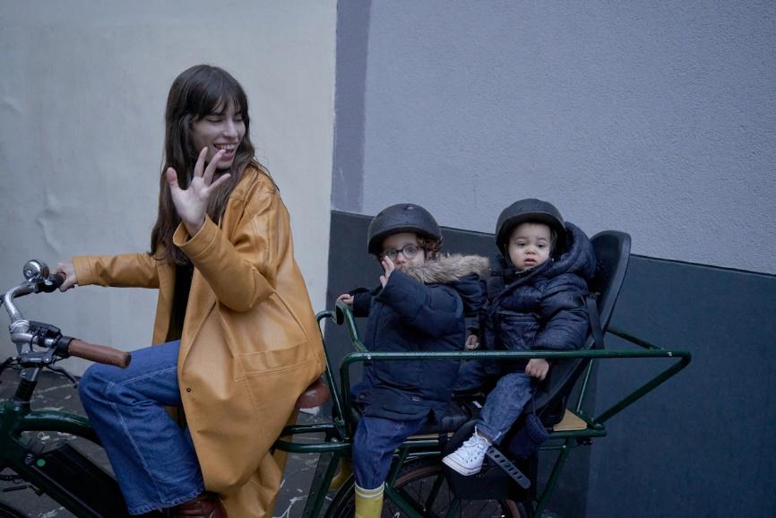 Une femme avec ses enfants sur un vélo cargo